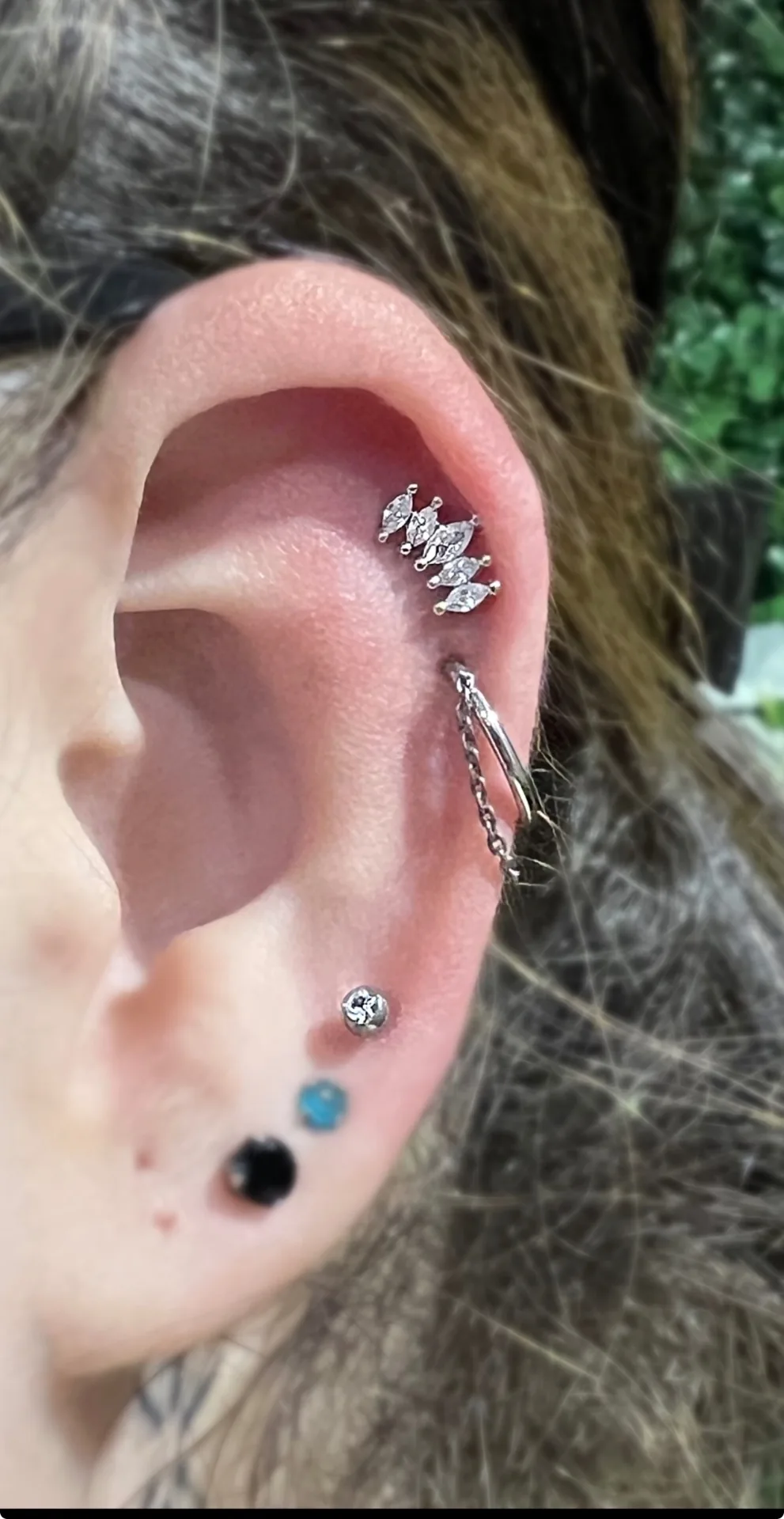 Piercing helix avec chaîne titane réalisé au studio Showtime Tattoo Paris
