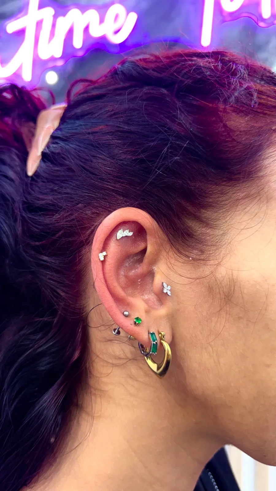 Piercing oreille émeraude luxe réalisé au studio Showtime Tattoo Paris Châtelet