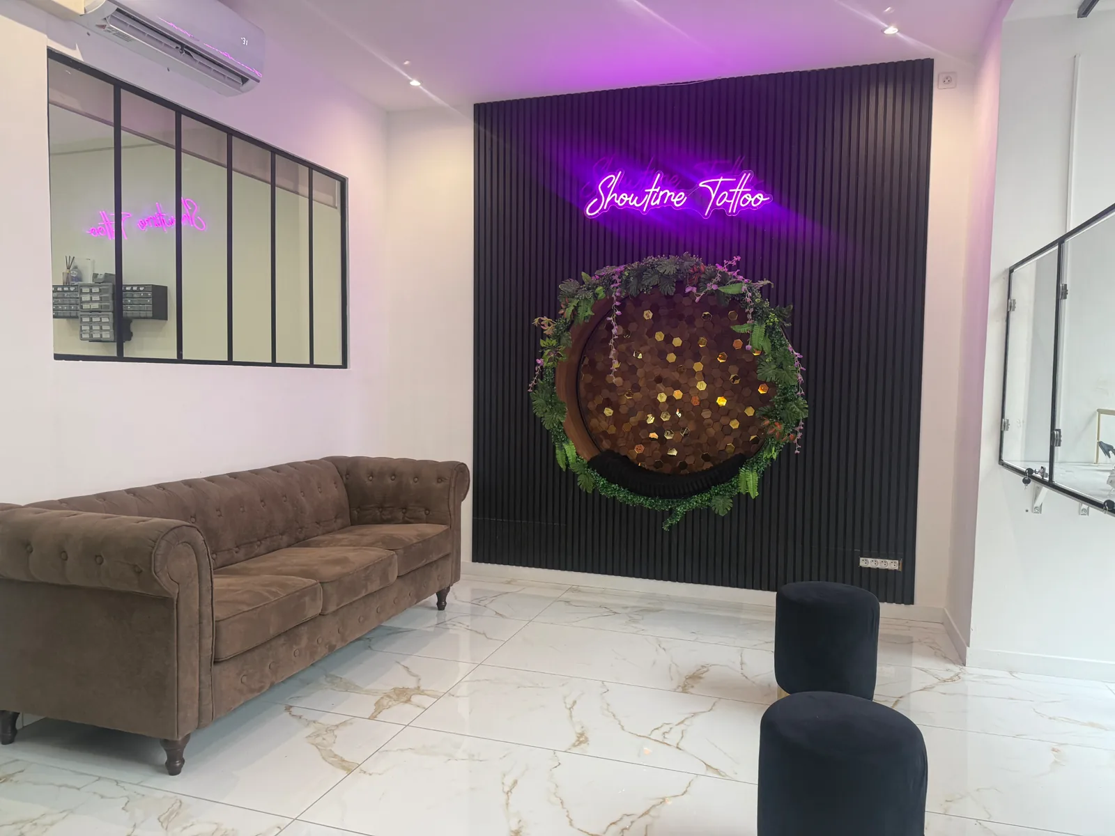 Salon attente luxe Showtime Tattoo Paris avec enseigne néon et décoration murale élégante