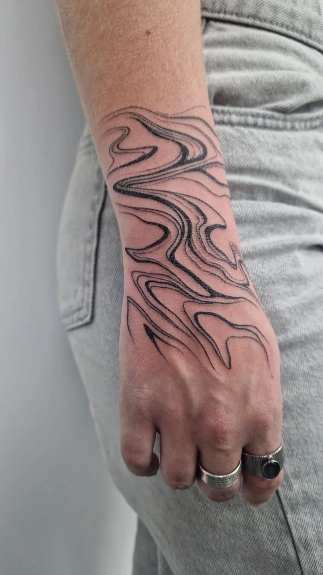 Tatouage abstrait vagues lignes sur avant-bras réalisé au studio Showtime Tattoo Paris Châtelet
