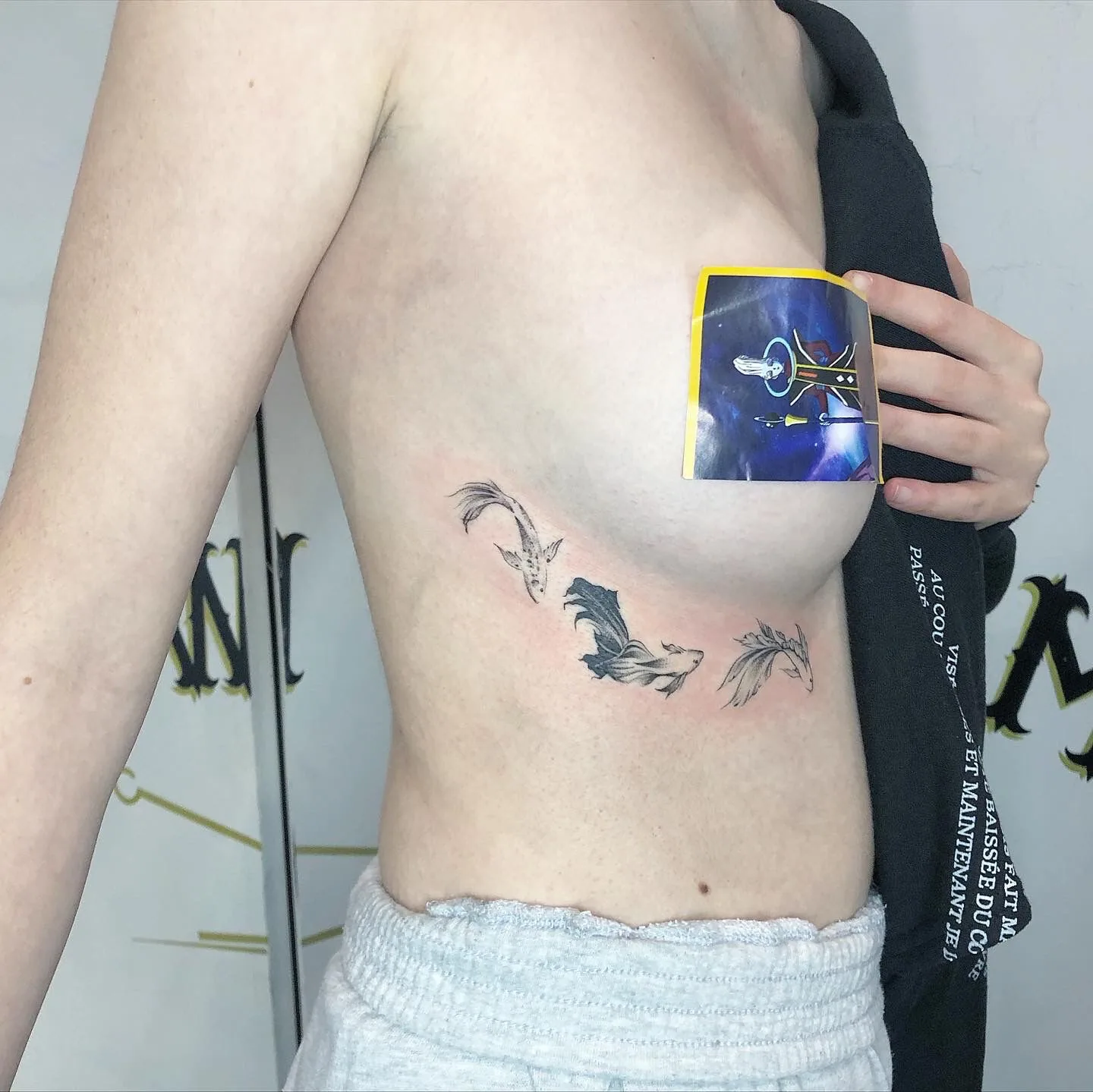 Tatouage poissons koi fineline sur côtes réalisé au studio Showtime Tattoo Paris Châtelet
