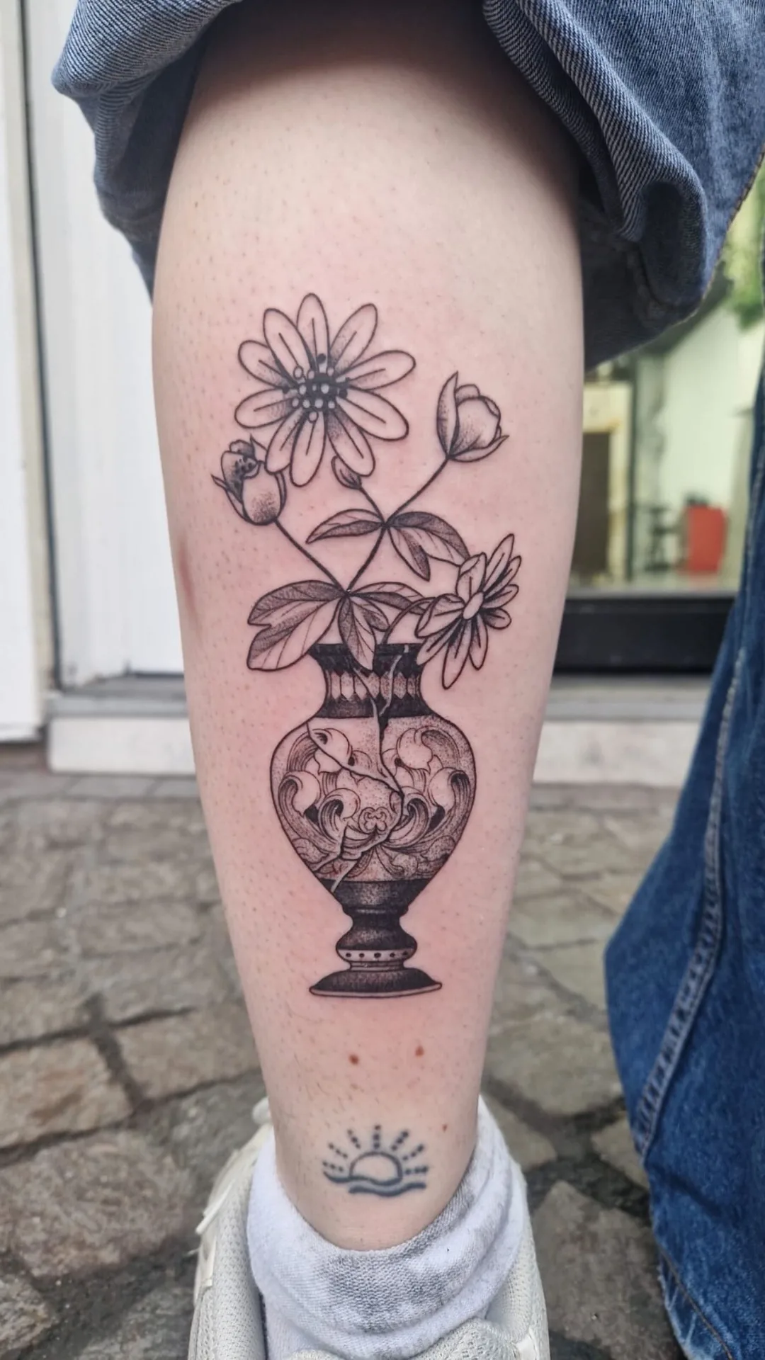 Tatouage vase fleurs blackwork sur mollet réalisé chez Showtime Tattoo Paris professionnel